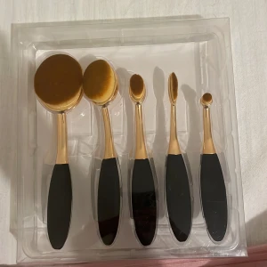 Set med ovala sminkborstar - Elegant set med fem ovala sminkborstar i guld och svart. Perfekt för att applicera foundation, concealer och ögonskugga med precision. Borstarna har ett ergonomiskt handtag för bekväm användning. 300kr för båda och 250kr för set och 50kr för den andra
