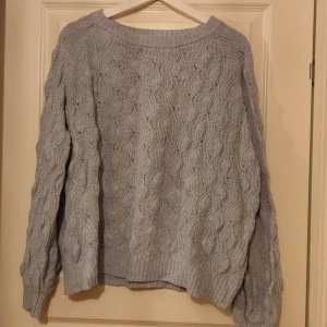 Ljusblå stickad tröja från KappAhl - Mysig stickad tröja från KappAhl med ett vackert vågigt mönster. Perfekt för kyliga dagar med sina långa ärmar och ribbade kanter. En klassisk och stilren design som passar till många tillfällen.