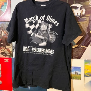 Svart vintage t-shirt med March of Dimes-tryck - Cool svart t-shirt från Global med tryck för March of Dimes 'Ride for Healthier Babies'. Framsidan har ett vintageinspirerat motiv med en motorcykel och barn. Baksidan visar sponsorer och texten 'VARYD 4 BBY Virginia'. Perfekt för dig som gillar retrostilen! Sitter som M-L  Dm vid frågor