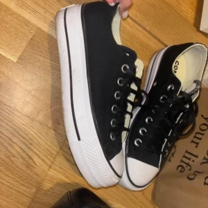 Svarta Converse All Star sneakers - Säljer ett par klassiska svarta Converse All Star sneakers i storlek 37. De har en vit sula och snörning framtill. Perfekta för vardagsbruk och ger en cool touch till vilken outfit som helst. Använda men i bra skick!