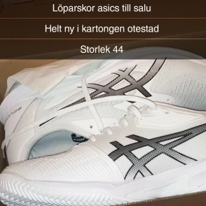 Vita löparskor från Asics - Säljer ett par helt nya vita Asics löparskor, modell Solution Speed FF 3 Clay. Skorna har en stilren design med svarta detaljer och snörning. Perfekta för löpning och andra aktiviteter 