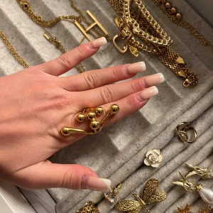 Unik guldring med kulor - Säljer en supercool guldring med en unik design av flera sammanlänkade kulor. Den är i mycket bra skick och perfekt för att ge en extra touch till din outfit. Passar både till vardag och fest. 💫 ringen är rostfri