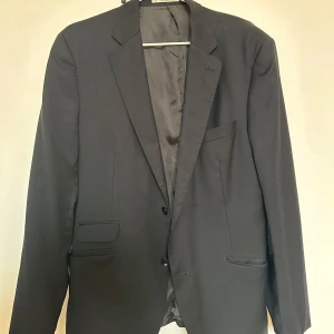 Svart oversize kavaj - Svart oversize kavaj i pure wool från the Tailoring club. Strl eur 54, sitter bra oversize på mig som har strl 36. Finns en reva på insidan (se bild) 