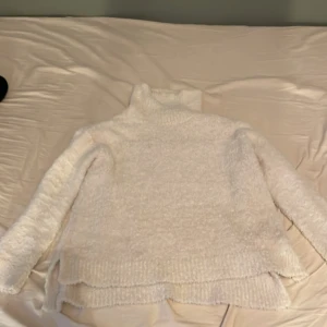 Vit fluffig polotröja från BikBok - Mysig vit polotröja från BikBok i fluffigt material. Perfekt för kyliga dagar med sin höga krage och långa ärmar. Tröjan har en avslappnad passform och är superbekväm att bära.