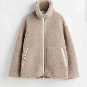 Beige teddyjacka med dragkedja - Mysig beige teddyjacka med dragkedja och stora fickor framtill. Perfekt för kyliga dagar med sin fluffiga och varma design. Jackan har en hög krage för extra värme och stil. Och pytte pytte liten sminkfläck men går lätt bort och syns knappt kolla sista bilden 