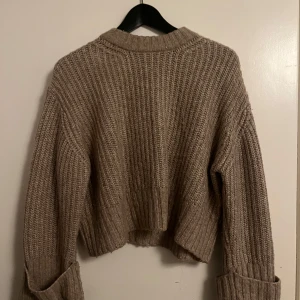 Beige stickad tröja från Gina Tricot - Säljer en supermysig beige stickad tröja från Gina Tricot strl S. Använd fåtal gånger. Perfekt för kyliga dagar med sin croppade stil och långa ärmar. Den har en ribbad design som ger en snygg look. Passar perfekt till både jeans och kjol!