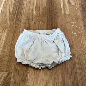 Vita shorts från H&M - Söta vita shorts från H&M för små barn. De har en elastisk midja och är gjorda i ett mjukt material, perfekt för varma dagar.