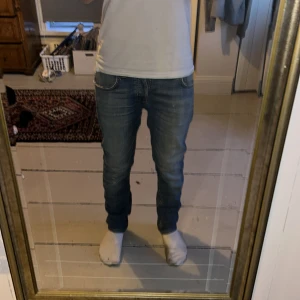 Blå jeans från Nudie Jeans - Säljer ett par klassiska blå jeans från Nudie Jeans. De har en lite mer slim passform och är tillverkade i denim. Perfekta för en avslappnad stil.