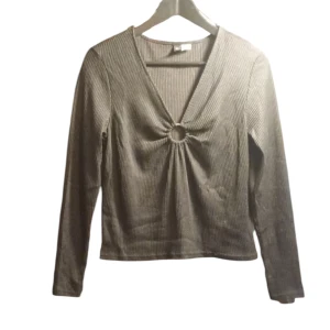 Svart ribbad topp med ringdetalj - En svart ribbad topp med en unik ringdetalj framtill. Toppen har långa ärmar och en v-ringad design som ger en stilren look. Perfekt för att lyfta din outfit!