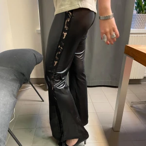 SVARTA SKINNBYXOR MED SPETSKANT - Svarta skinnbyxor med spetskant längs sidorna!! Älskar dessa skinnbyxor speciellt då spetsen på sidan gör de så snygga! Tjejen på bilden är 175 cm lång, hör av er för mått och frågor!!