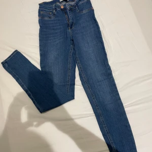 Blå jeans från Perfect Jeans - Säljer ett par snygga blå jeans från Perfect Jeans, modell Molly. De är i bra skick och har en klassisk femficksdesign med knapp och dragkedja framtill. Perfekta för både vardag och fest! Skön stretch i sig! 