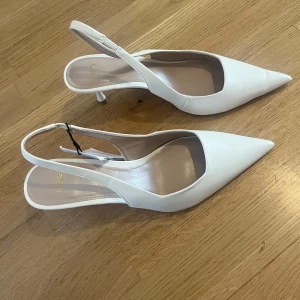 Vita pumps från mango (nya) - Säljer dessa oanvända eleganta vita pumps från Mango med prislapp kvar. De är i storlek 37. Klackarna har en spetsig tå och en smal klack. Skorna har en stilren design med en smal rem runt hälen. Perfekta för att lyfta vilken outfit som helst!😍 nypris 419kr