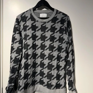 Svart och grå mönstrad tröja från samsoe samsoe - Säljer en snygg svart och grå tröja med ett coolt rutigt mönster från samsoe samsoe. Tröjan är långärmad och perfekt för både höst och vinter. Den har en bekväm passform och är gjord i ett mjukt material. Perfekt för att hålla stilen när det blir kallare!