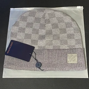 Grå mössa  - Snygg och stilren grå mössa i ett rutigt mönster. Mössan är i nytt skick och har en ribbad kant med en diskret logotyp. Perfekt för att hålla sig varm.☺️ skick 10/10 priset kan såklart diskuteras 