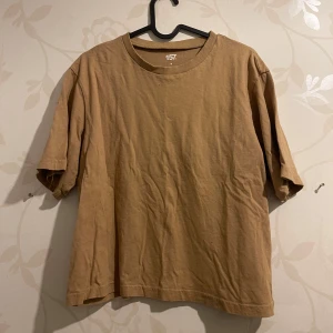 Beige t-shirt - Säljer en enkel och stilren beige t-shirt. Den har en normal passform och är kortärmad, perfekt för vardagsbruk. Materialet känns mjukt och bekvämt, vilket gör den idealisk för både sommar och vår. Passar bra till jeans eller shorts för en avslappnad look.