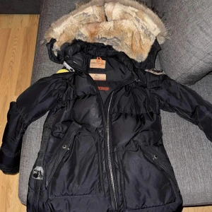 Svart vinterjacka från Parajumpers - Säljer en svart Parajumpers vinterjacka med pälsfodrad huva. Jackan har en dragkedja, samt flera praktiska fickor. Perfekt för kalla vinterdagar! 🖤