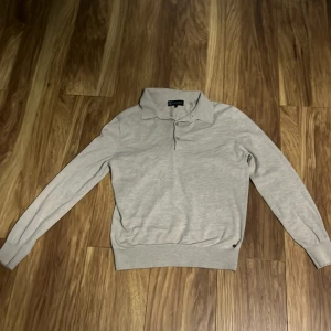 Beige polotröja från Lagency - Säljer en stilren beige polotröja från Lagency i storlek S. Tröjan är i bra skick och har långa ärmar. Perfekt för både vardag och lite finare tillfällen. Den är mjuk och bekväm, vilket gör den idealisk för höst och vår. Nypris:1700kr. Priset kan även diskuteras.