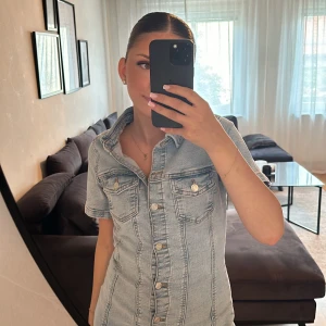 Jeansklänning från ASOS Design - Säljer en snygg jeansklänning från ASOS Design i ljus denim. Klänningen har korta ärmar och knappar framtill. Perfekt för en avslappnad sommarlook! 🦋pris kan diskuteras💗