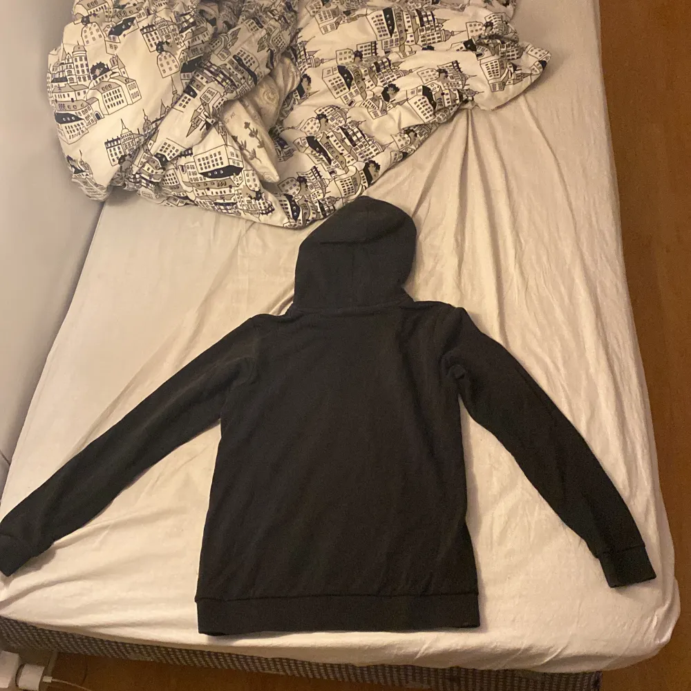 Säljer en svart hoodie från Peak Performance i bra skick. Den har en klassisk design med logga på bröstet och en stor ficka framtill. Perfekt för höst och vinter när du vill hålla dig varm och bekväm. Passar både till vardags och träning. Storlek 170cm.. Hoodies.