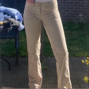 Beige byxor från Esprit - Säljer ett par snygga lågmidjade beige byxor/cargos från Esprit. De har en bootcut-stil och är perfekta för både vardag och fest. Identiska till IAMGIA Ryder cargo pants. Byxorna har två knappar och dragkedja framtill, vilket ger en säker passform. Materialet känns bekvämt och passar bra till olika outfits. Perfekta för höst och vår!
