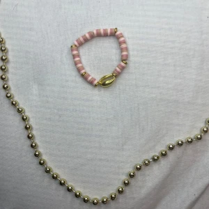  rosa armband med snäckdetalj - Säljer ett sött rosa armband med gulddetaljer och en snäcka. Armbandet har små rosa och vita pärlor som ger en somrig känsla. Perfekt för att piffa upp vilken outfit som helst!💫💕