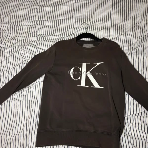 Brun sweatshirt från Calvin Klein - Säljer en snygg brun sweatshirt från Calvin Klein. Tröjan är i mycket bra skick och är i storlek Medium