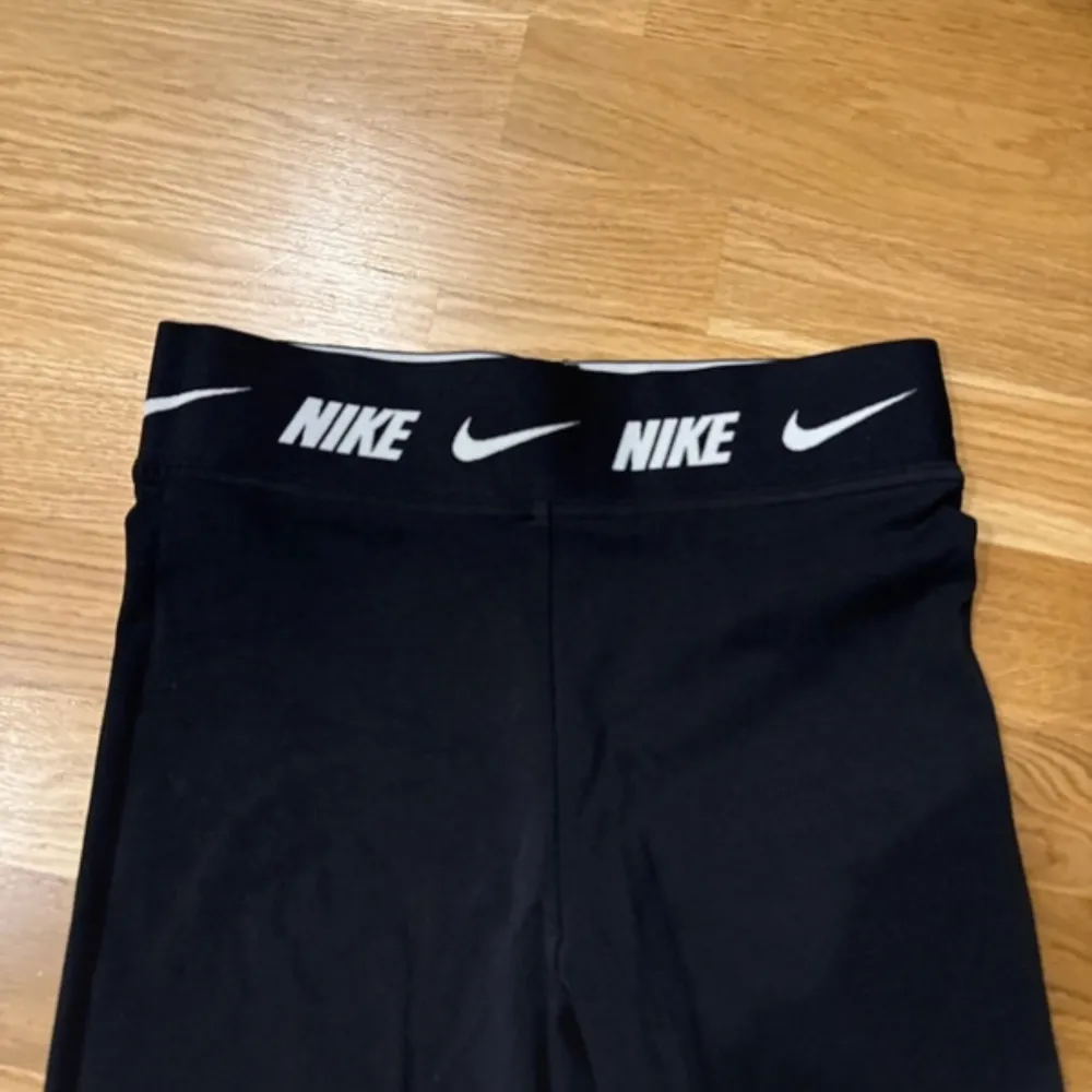 Säljer ett par svarta leggings från Nike i mycket bra skick. De är högmidjade med en elastisk midja som har Nike-loggan runtom. Perfekta för träning eller en chill dag hemma. Materialet är mjukt och stretchigt för bästa komfort.. Jeans & Byxor.