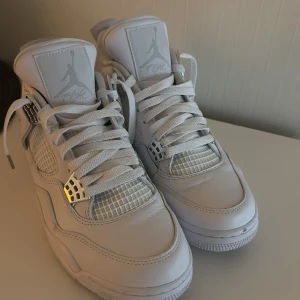 Jordan’s 4 pure money  - Säljer ett par vita Nike Air Jordans i mycket bra skick. De har en klassisk design med snörning och är tillverkade i skinn. Perfekta för vardagen. Har bara använts 2 gånger.