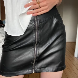 svart skinnkjol med dragkedja XS - svart mini skirt i läderimmitation med dragkedja & fickor! passar XS-S