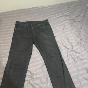 Svarta jeans från H&M - Säljer ett par svarta jeans från H&M i straight regular fit. De är i bra skick och har en klassisk design med fem fickor och knappgylf. Perfekta för både vardag och fest!