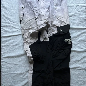 Svart och vit byxa från Dope - Säljer ett par coola byxor från Dope i svart och vitt. De har en loose passform och är perfekta för vintern. Byxorna har praktiska fickor och en snygg logga på sidan. Perfekta för att hålla stilen i backen eller på stan! Finns även en matchande jacka ute lite längre ner på min profil. Om man vill köpa båda skulle man kunna få ett paket pris!