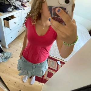 Rosa V-ringad T-shirt - Säljer en snygg rosa T-shirt med V-ringning. Den är i bomull och har korta ärmar. Perfekt för sommaren eller vardagsbruk. Den är i bra skick och väldigt bekväm att ha på sig. Passar bra till jeans eller kjol!