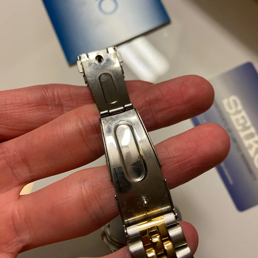 Säljer en discontinued Seiko herrklocka med guldpläterad armband. Klockan är i bra skick med minimala repor, dock behövs ett nytt batteri då den inte tickar. Den har ett kvartsurverk och är vattentät. Klockan kommer med originalbox och papper.. Accessoarer.