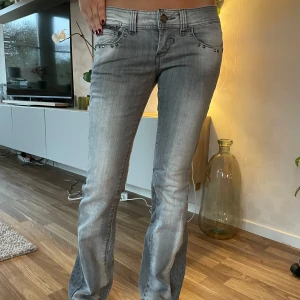 Lågmidjade jeans - Ett par grå jeans med coolt leopardmönster längs sidorna. De är lågmidjade och har en bootcut-stil. Jeansen har snygga nitar vid fickorna mini-dragkedja nere på baksida ben. Perfekta för båda fest och vardag. 🐆🩶Alla mått finns på bild 5. Skriv för frågor.