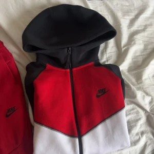 Röd och svart Nike tech - Säljer min Nike tech. Byxorna är i storlek L och hoodien i storlek M. Inga flaws utan väldigt bra skick. 