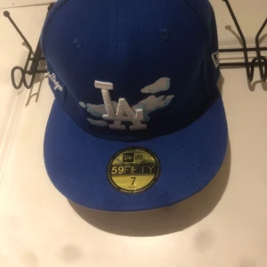 Blå keps från New Era - Säljer en blå New Era 59FIFTY keps med LA-logga framtill. St 7 (55,8) cm. Ny skick
