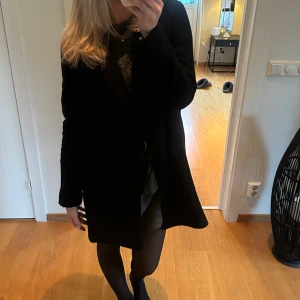 Svart kappa - Säljer min stilrena svarta kappa i mycket bra skick. Perfekt för höst och vår, och funkar lika bra till vardags som till fest!