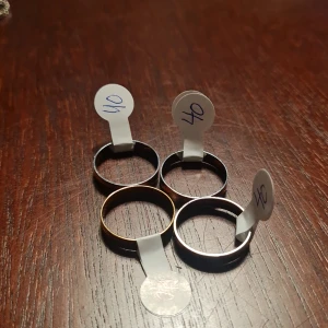 Olika ringar i metall - Säljer ett gäng olika ringar i metall. Första bilden visar enkla släta ringar i silver och guldtoner. Andra bilden har två ringar med små hängande berlocker. Tredje bilden visar ringar med ett lövmönster. Fjärde bilden har tunna kedjeliknande ringar i olika färger. Perfekt för att mixa och matcha! Storlek: 13,14,15,16,21 Pris: 40:-