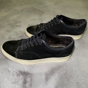 Navy Lanvin Cap Toe - Säljer mina Lanvins i Uk storlek 9, passar dit i storlek 43-44 i skostorlek. Skorna är i okej skick, använde men har mycket kvar att ge. Liten slitning inuti skon som ej märks, Hör av dig med frågor