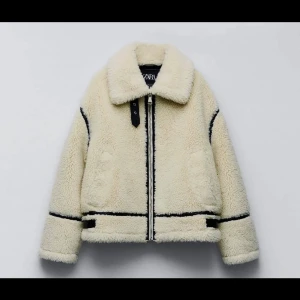 Beige teddyjacka från Zara - Supermysig  teddyjacka från Zara med svarta detaljer. Perfekt för kyliga dagar med sin fluffiga och varma design. Jackan har en dragkedja framtill och långa ärmar.  Ord pris 1100kr. Storlek M