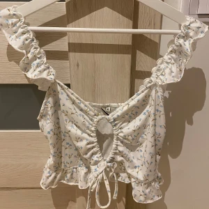 Blommig topp - Supergullig topp med blå små blommor. Aldrig använd, prislappen är kvar! Tyvärr ingen bild på då den är för stor för mig.