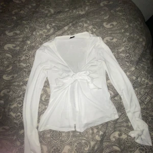 Vit långärmad topp Gina Tricot - Säljer en stilren vit långärmad topp från Gina Tricot i storlek M. Inga hål eller något sånt, använd 1 gång