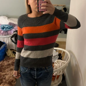 Randig tröja i flera färger kashmir - Säljer en superfin randig tröja med färger i grått, orange, rött och beige. Tröjan är i kashmir, köpt på arkivet och står tyvärr inget märke! Tröjan har tydliga sömmar🔥🔥