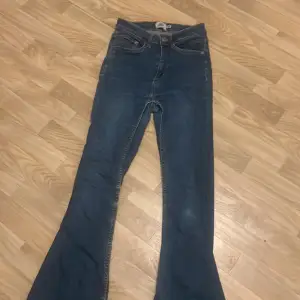 Säljer ett par snygga blå jeans från 157 i storlek XS. De har en cool flare-stil som ger en retro vibe. Perfekta för både vardag och fest! 🕺