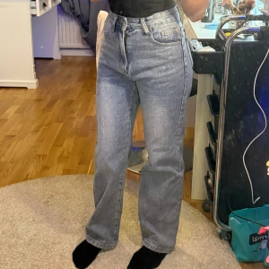 Grå jeans med hög midja - Säljer ett par snygga blå jeans med hög midja. De har en klassisk straight fit och är perfekta för  vardag. Jeansen är i mycket bra skick och passar perfekt till en avslappnad stil. Perfekta för höst, vår och också sommar 