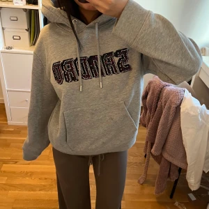 Grå hoodie från Sandro - Säljer en snygg grå hoodie från Sandro storlek xs, vissa stenar/paljetter har ramlat av men inget man märker pris går att diskutera