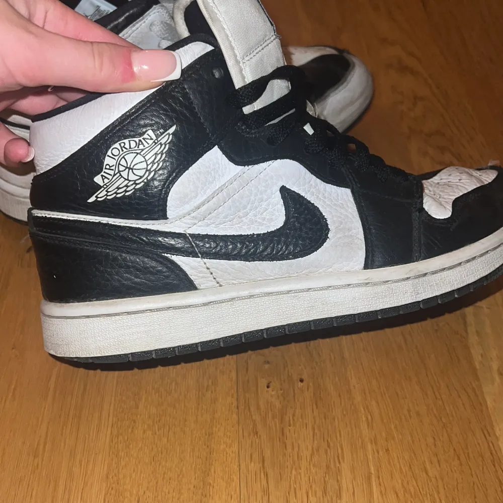 Säljer ett par klassiska svartvita Nike Air Jordans i bra skick. Skorna har en hög modell med snörning och den ikoniska Air Jordan-loggan på sidan. Perfekta för både vardag och fest! De har lite slitage men är fortfarande riktigt snygga och bekväma. Du kan absolut putsa upp de själv! Skolåda medkommer ej!. Skor.