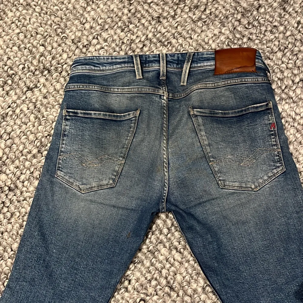 Säljer ett par snygga blå jeans från Replay med coola slitningar för en trendig look. De har en klassisk femficksdesign och en bekväm passform. Perfekta för både vardag och fest! 🕺köpte dem för 1799kr på NK🙌🏾. Jeans & Byxor.