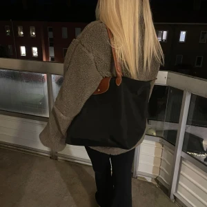 Svart longchamp väska L - Säljer en stilren svart axelväska med bruna läderdetaljer från Longchamp! Modellen heter Väska le pliage original tote l black. Perfekt för vardagsbruk med gott om plats för alla dina saker. Väskan har en klassisk design och är i mycket bra skick. Passar till alla säsonger och outfits! Nypris 1599❤️