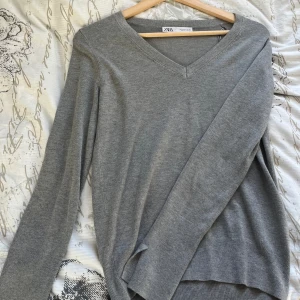 V-ringad tröja från Zara - Säljer denna superfina tröja från Zara. Stickad tröja med små slitsar på ärmarna, storlek S. Knappt använd ❣️